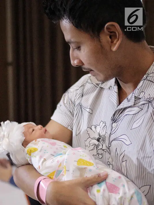 Suami artis Fairuz A Rafiq, Sonny Septian menggendong bayi perempuan mereka di Jakarta, Selasa (22/5). Bayi perempuan tersebut lahir dengan berat 2.900 gram dan panjang 47 centimeter. (Liputan6.com/Faizal Fanani)