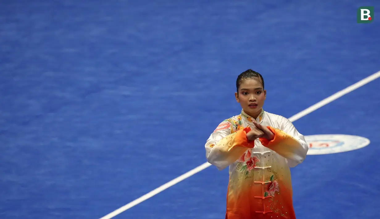 Atlet Wushu Indonesia, Alisya Mellynar saat bertanding dalam cabang olahraga Wushu nomor Taolu Tajiquan Wanita SEA Games 2021 yang berlangsung di Cau Giay Gymnasium, Hanoi, Sabtu (14/5/2022). Ia berhasil meraih medali emas setelah mengumpulkan skor 9,71. (Bola.com/Ikhwan Yanuar)