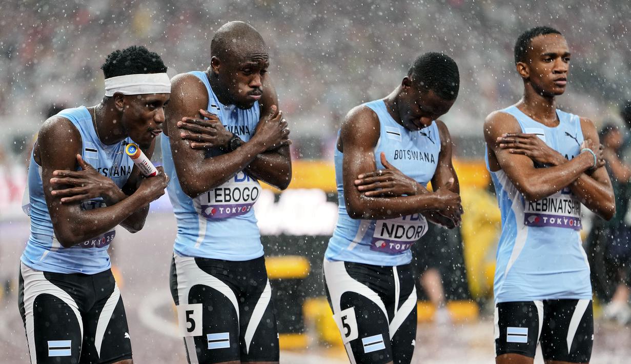 Tim Botswana terlihat kedinginan saat hujan sebelum dimulainya nomor estafet 4x400 meter putra dalam ajang Kejuaraan Dunia Atletik 2025 di Tokyo, Jepang, Minggu (21/09/2025). (AP Photo/Eugene Hoshiko)