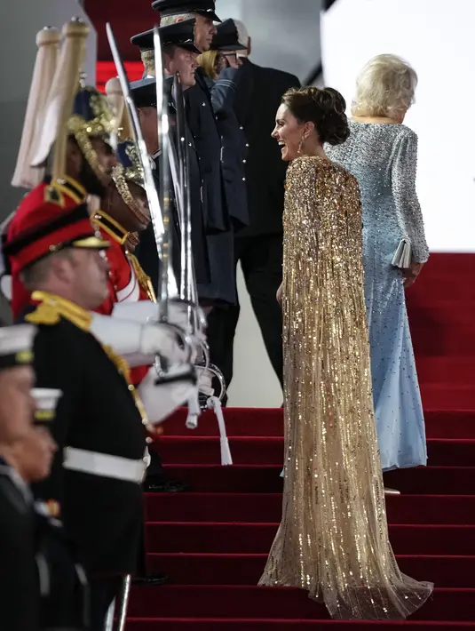 Kate Middleton berbicara dengan seorang anggota militer pada saat tiba pemutaran perdana premier film James Bond terbaru, No Time To Die, di London, Selasa (28/9/2021). Jika biasanya Kate hanya menggerainya, rambut ibu tiga anak itu kini disanggul dengan tatanan agak rumit. (AP Photo/Matt Dunham)