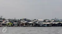 Suasana pemukiman kumuh dari tepi pantai di kawasan kali Adem, Muara Angke, Jakarta Utara, Senin (2/1). Pemukiman nelayan tersebut akan direlokasi oleh Pemprov DKI Jakarta ke rusun Muara Baru untuk revitalisasi pelabuhan. (Liputan6.com/Faizal Fanani)