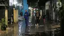 Warga berjalan menerjang banjir karena hujan di Jalan Shofa Marwah, Jakarta, Jumat (4/11/2022). Berdasarkan laporan Badan Penanggulangan Bencana Daerah (BPBD) DKI Jakarta yang diperbaharui pada pukul 18.00 WIB, terdapat 4 RT yang terendam banjir dengan ketinggian maksimal mencapai 50 Cm. (Liputan6.com/Faizal Fanani)