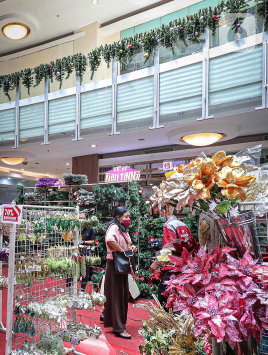 Calon pembeli memilih pernak-pernik Natal di Mal Artha Graha, Jakarta, Sabtu (4/12/2021). Jelang perayaan Natal 25 Desember sejumlah mal di ibukota mulai menjual berbagai kebutuhan Natal mulai dari pernak-pernik hingga pohon Natal dengan kisaran harga Rp10.000-Rp5 juta. (Liputan6.com/Faizal Fanani)