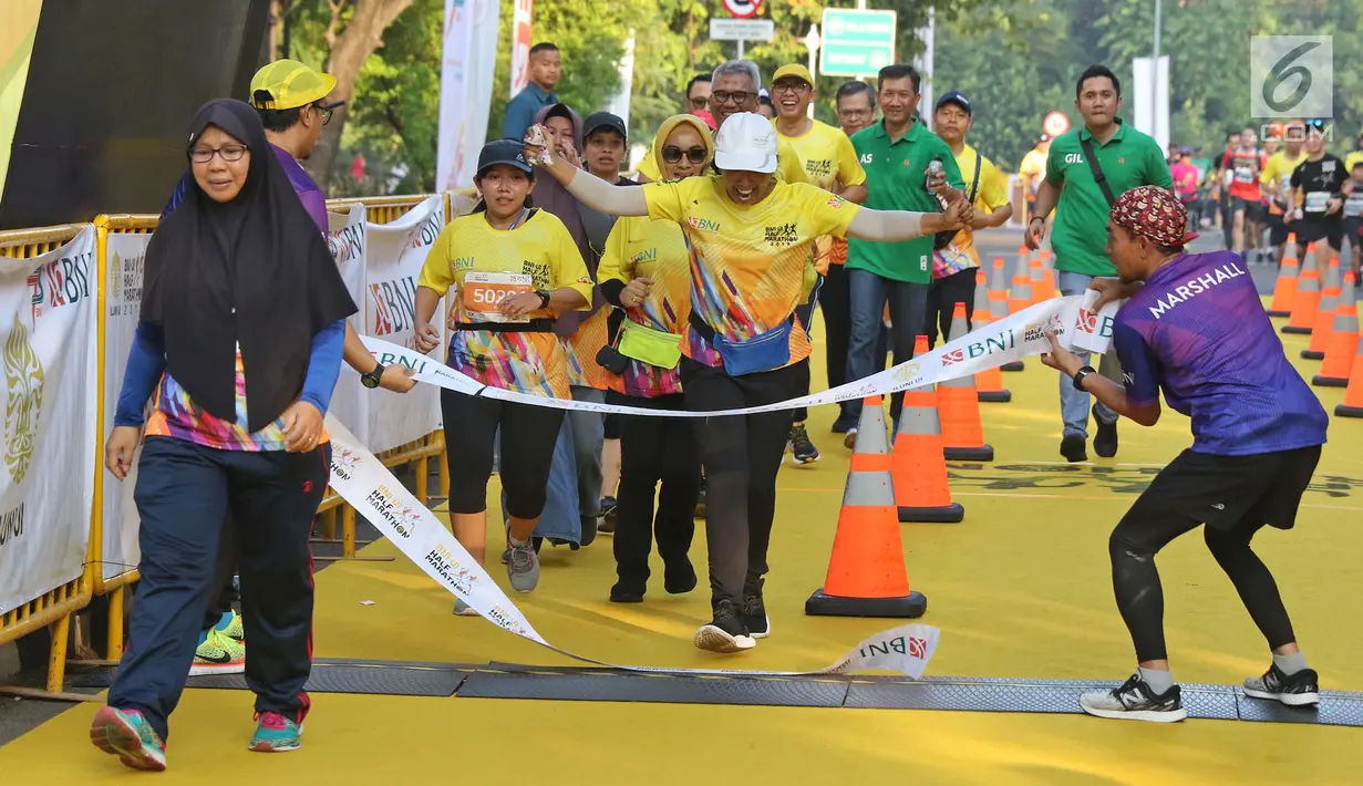 Menteri BUMN Rini Soemarno saat mencapai garis finish pada acara BNI-UI Half Marathon 2019 di Kampus Universitas Indonesia, Depok, Jawa Barat, Minggu (7/7/2019). BNI UI Half Marathon 2019 diselenggarakan dalam rangka merayakan HUT ke-73 BNI. (Liputan6.com/Herman Zakharia)