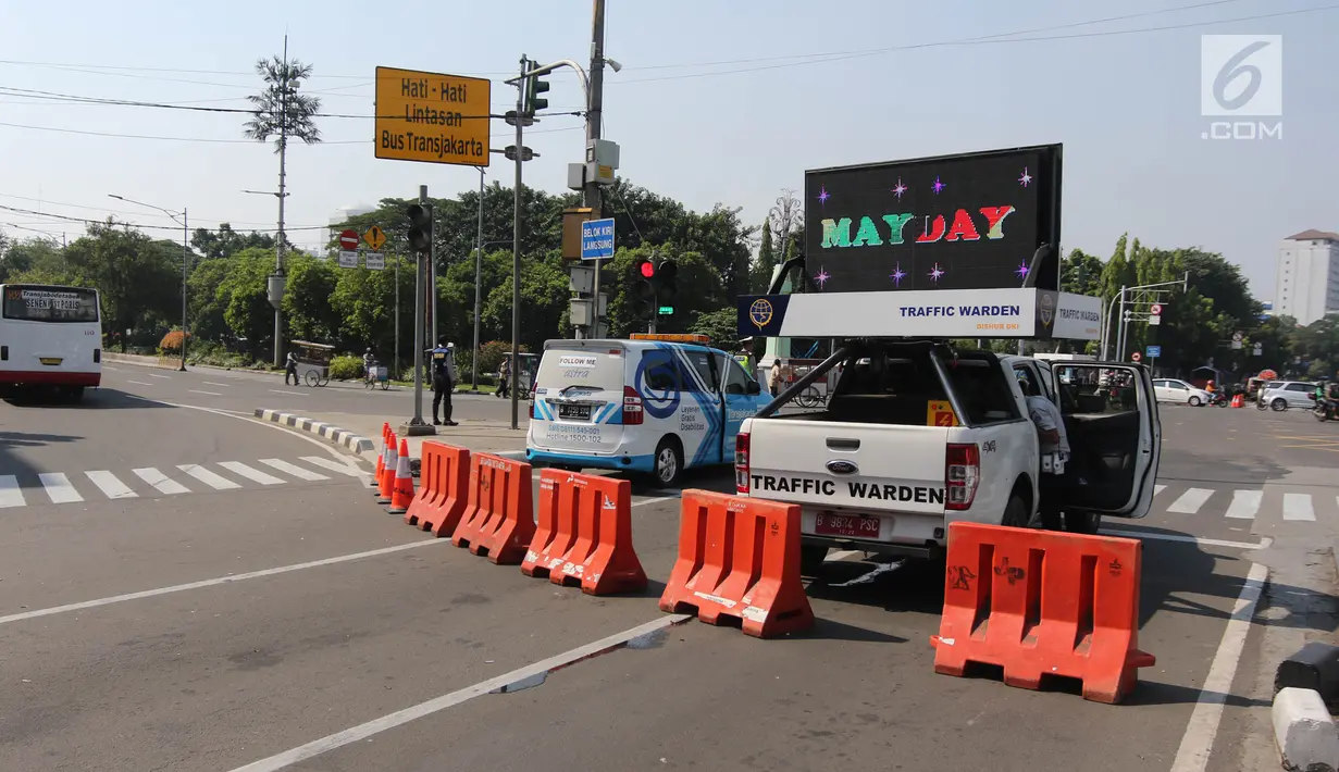 Petugas melakukan rekayasa lalu lintas imbas dari kegiatan May Day 2018 di kawasan Harmoni, Jakarta Pusat, Selasa (1/5). Rekayasa lalin diberlakukan di sejumlah titik aksi di Jakarta. (Liputan6.com/Arya Manggala)