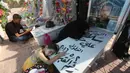 Keluarga mengunjungi makam kerabat mereka di pemakaman Wadi al-Salam, di Najaf, selatan Baghdad, Irak, 5 Agustus 2016. Sebagian besar masyarakat Irak meyakini banyak jasad raja, pangeran dan sultan bersemayam di sana. (REUTERS/Alaa Al-Marjani)