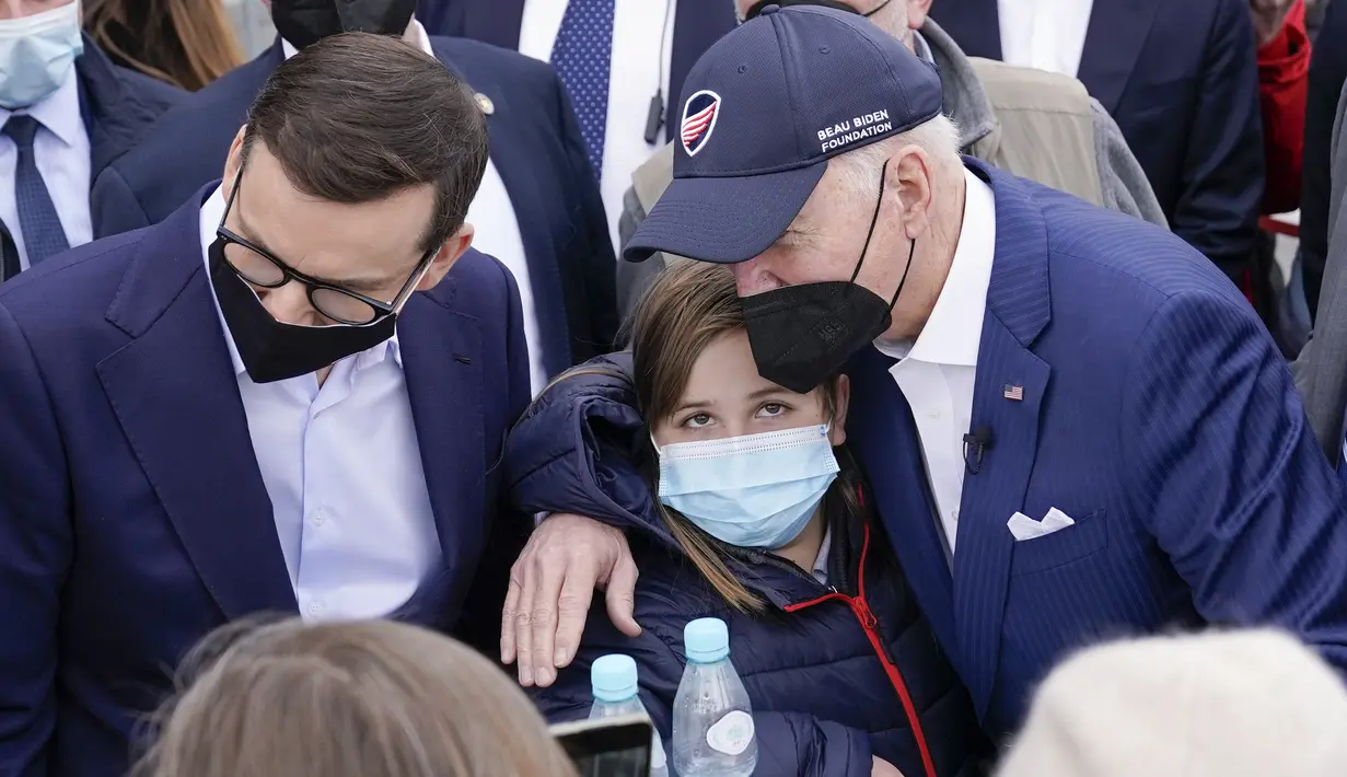 Presiden Amerika Serikat Joe Biden merangkul seorang gadis saat bertemu dengan pengungsi Ukraina dan pekerja bantuan kemanusiaan pada kunjungan ke PGE Narodowy Stadium di Warsawa, Polandia, 26 Maret 2022. (AP Photo/Evan Vucci)