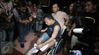 Alfin Bernius Sinaga, supir perampokan disertai pembunuhan di Pulomas saat digiring petugas menggunakan kursi roda ke ruang ICCU RS Polri, Kramatjati, Jakarta Timur, Kamis (29/12). (Liputan6.com/Yoppy Renato) 