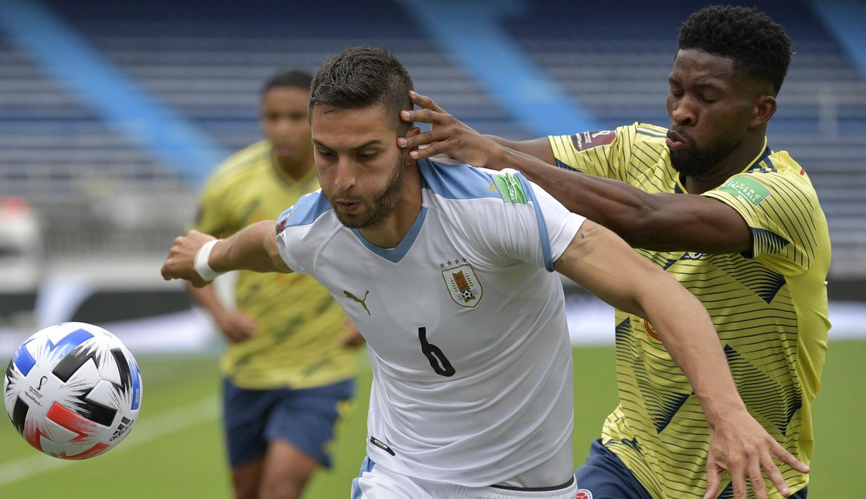Gelandang Uruguay, Rodrigo Bentancur, berebut bola dengan gelandang Kolombia, Jefferson Lerma, pada laga kualifikasi Piala Dunia 2022 zona CONMEBOL di Estadio Metropolitano Roberto Melendez, Sabut (14/11/2020) dini hari WIB. Uruguay menang 3-0 atas Kolombia. (AFP/Raul Arboleda)