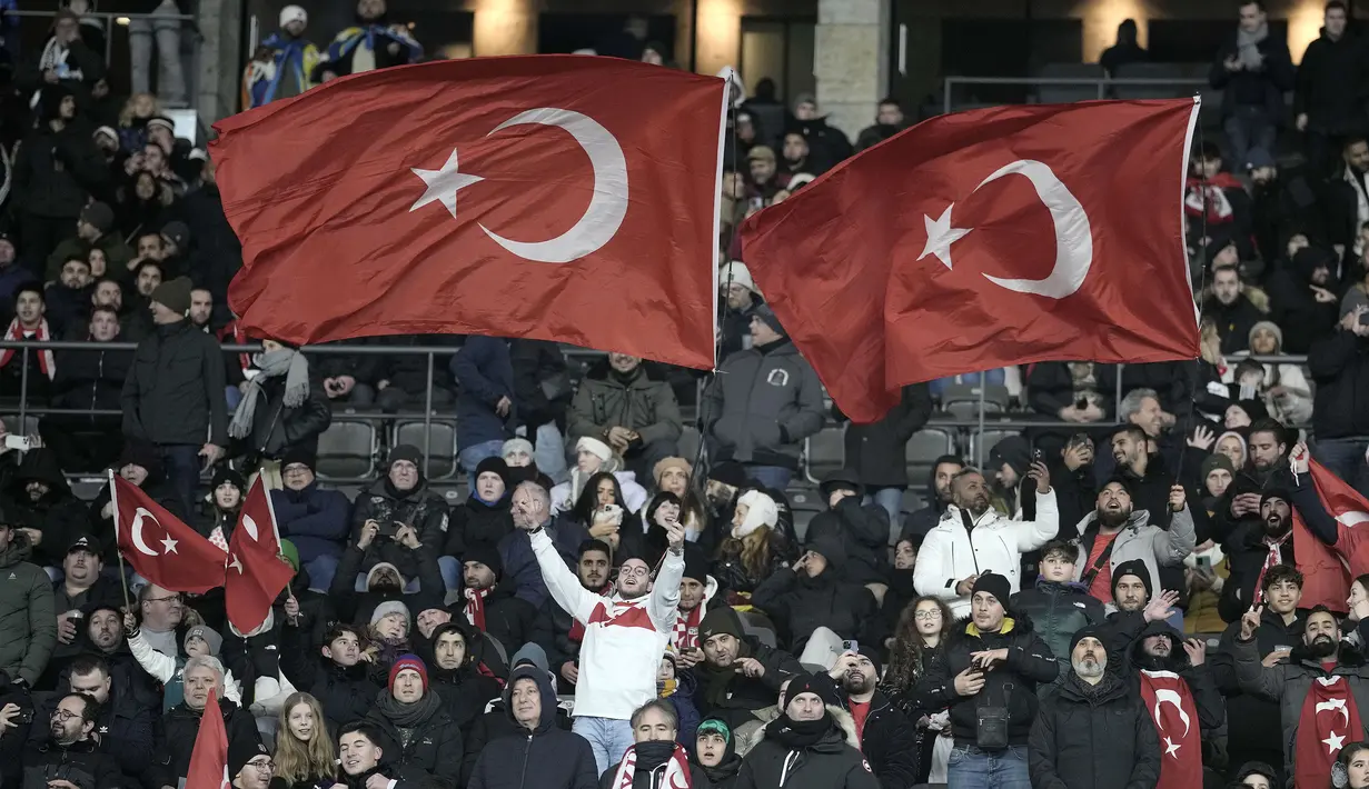 Para suporter Turki mengibarkan bendera Turki sebelum dimulainya laga uji coba internasional antara Timnas Jerman menghadapi Timnas Turki di Olympiastadion, Berlin, Minggu (19/11/2023) dini hari WIB. (AP Photo/Markus Schreiber)