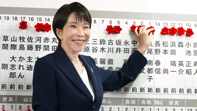 Sanae Takaichi, perdana menteri Jepang dan presiden LDP, memasang pin penanda kandidat pemenang pemilu Majelis Rendah di kantor pusat LDP di Tokyo, Minggu (8/2/2026).