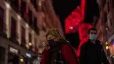 Orang-orang yang memakai masker berjalan di pusat kota Madrid, Rabu (22/12/2021). Perdana Menteri Spanyol Pedro Sanchez mengadakan rapat Kabinet khusus untuk mengesahkan undang-undang yang mewajibkan penggunaan masker di luar ruangan di tengah lonjakan rekor kasus COVID-19. (AP Photo/Manu Fernandez)
