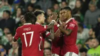 Striker Manchester United, Marcus Rashford (kanan) disambut rekan-rekannya dengan merayakan gol ke gawang Real Betis pada leg kedua babak 16 besar Liga Europa 2022/2023, Jumat (17/3/2023) dini hari WIB. (AP Photo/Jose Breton)