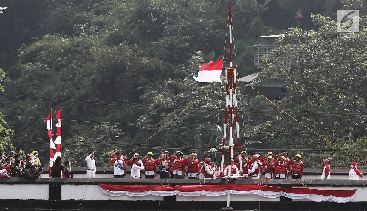 Peserta mengikuti upacara bendera peringatan HUT Kemerdekaan RI di Jembatan Panus, Depok, Kamis (17/8). Komunitas Ciliwung Depok mengibarkan bendera Merah Putih di Jembatan Panus yang melintang di atas Sungai Ciliwung. (Liputan6.com/Herman Zakharia)