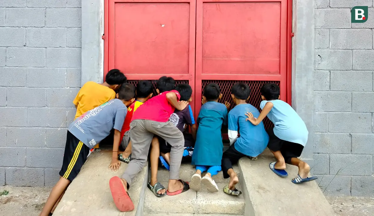Sejumlah anak mengintip sesi latihan Persija di lapangan indoor, Sawangan, Depok. (Bola.com/M Iqbal Ichsan)