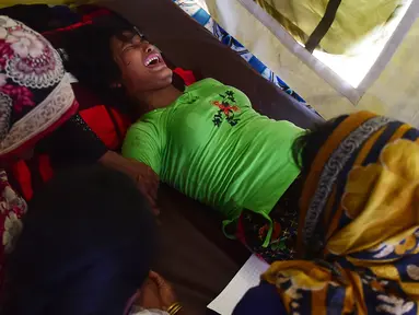 Seorang wanita Rohingya bernama Hasina Aktar bereaksi saat melahirkan di sebuah pusat medis di kamp pengungsian Kutupalong (11/10). Anak Hasina Aktar ini diberi nama Mohammed Jubayed. (AFP Photo/Munir Uz Zaman)