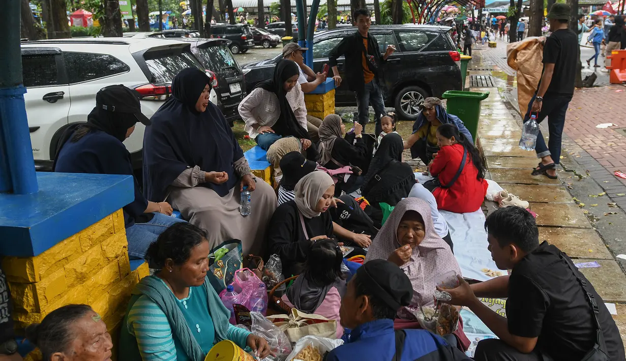 Meski diguyur hujan deras, sejumlah pengunjung tetap menyusuri area Kebun Binatang Ragunan, Jakarta. (merdeka.com/Arie Basuki)