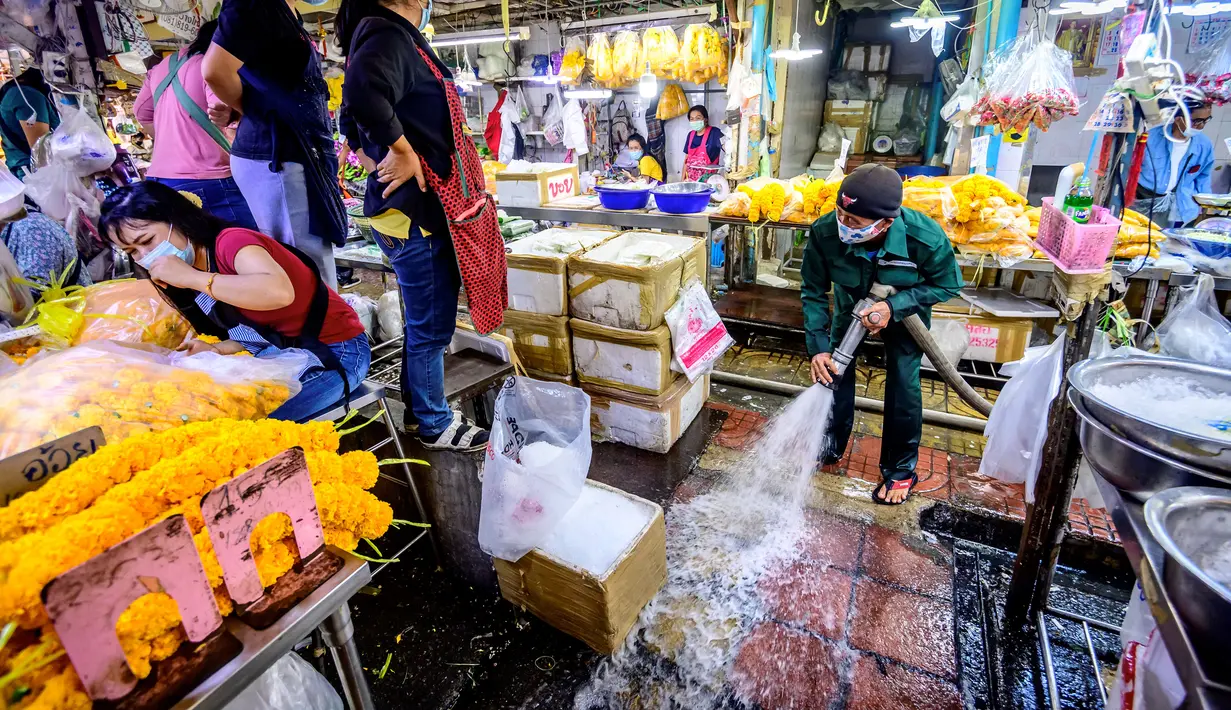 Pekerja Otoritas Metropolitan Bangkok menyapu lantai saat membersihkan dan mendisinfeksi Pasar Bunga Yodpiman di Bangkok (6/1/2021).  Thailand melaporkan 745 kasus virus corona baru hari ini, Senin (4/1/2020).  (AFP/Mladen Antonov)