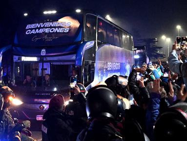 Para penggemar mengambil gambar bus yang mengangkut tim sepak bola nasional Argentina di Ezeiza, Buenos Aires, Argentina pada 15 Juli 2024. (Luis ROBAYO/AFP)