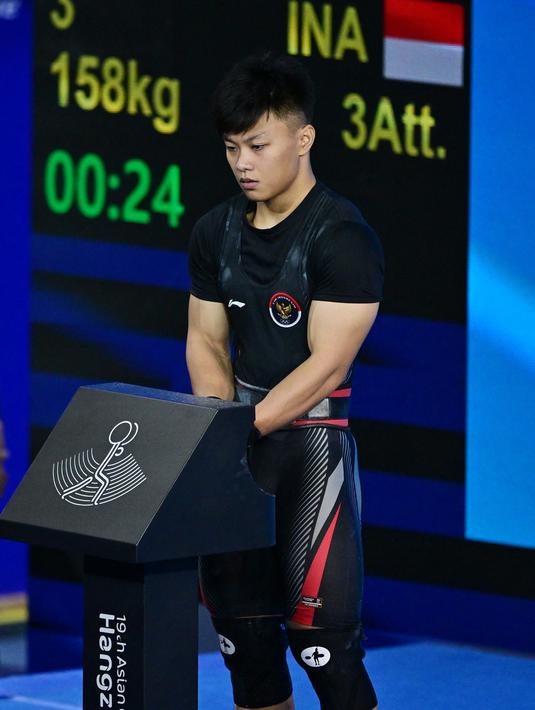 Rahmat Abdullah berhasil menambah pundi emas Indonesia usai menjadi yang terbaik di cabor Angkat Besi kelas 73 kg putra Asian Games 2023. (Ishara S.KODIKARA / AFP)