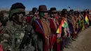 Tentara berbaris bersama pria Aymara menyanyikan lagu kebangsaan mereka saat pawai ulang tahun tentara Bolivia ke-192 di Kjasina, Bolivia (7/8). Hal ini unik dari upacara militer ini adalah karena digelar di tengah gurun. (AP Photo/Juan Karita)