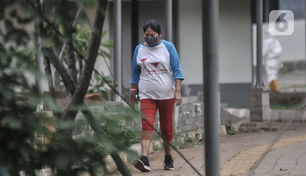 Pasien positif Covid-19 saat berolahraga di sekitar taman Rumah Sakit Darurat (RSD) Wisma Atlet, Kemayoran, Jakarta, Minggu (6/12/2020). Setiap pagi dan sore hari pihak RSD Wisma Atlet memperbolehkan pasien Covid-19 keluar kamar untuk berolahraga sekaligus menikmati udara segar. (merdeka.com/Iqbal N