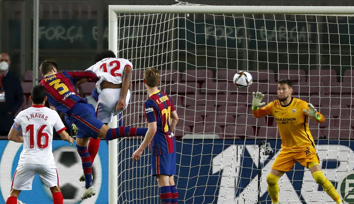 Bek Barcelona, Gerard Pique (kedua dari kiri) melepaskan sundulan yang berbuah gol kedua timnya ke gawang Sevilla dalam laga leg kedua semifinal Copa Del Rey 2020/21 di Camp Nou Stadium, Rabu (3/3/2021). Barcelona menang 3-0 melalui extra time dan lolos ke babak final. (AP/Joan Monfort)