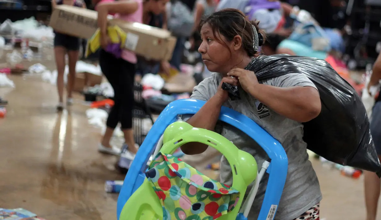 Seorang wanita membawa barang jarahannya dari sebuah toko di Veracruz, Meksiko, (5/1). Akibat kejadian tersebut mengakibatkan kematian seorang polisi dan seorang saksi. (AP Photo / Felix Marquez)