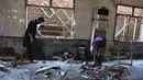 Petugas penyelamat memeriksa lokasi ledakan bom di sebuah madrasah di kota Peshawar, Pakistan, Selasa (27/10/2020). Berdasarkan keterangan saksi, ada seseorang membawa tas diduga berisi bom di dalam kelas dan meninggalkan ruangan sebelum ledakan. (AP Photo/Muhammad Sajjad)