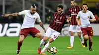 Gelandang AC Milan Hakan Calhanoglu berebut bola dengan gelandang  AS Roma Radja Nainggolan dalam laga lanjutan Serie A pekan ke-7 di San Siro, Minggu (1/10). Roma mampu mempermalukan Milan dengan skor 2-0. (MIGUEL MEDINA/AFP)