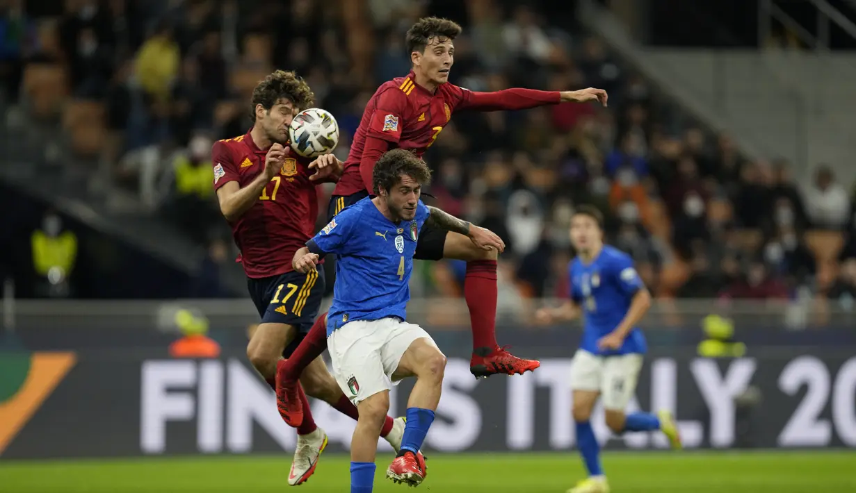 Bek Italia, Davide Calabria (tengah) berebut bola denga dua pemain Spanyol Marcos Alonso dan Pau Torres pada pertandingan semifinal UEFA Nations League di stadion San Siro di Milan, (7/10/2021).  Spanyol menang atas Italia 2-1. (AP Photo/Antonio Calanni)