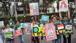 Sejumlah warga menunjukkan poster saat melakukan kampanye tentang perdamaian dunia saat car free day di kawasan Bunderan HI, Jakarta, Minggu (27/5). Kampanye tersebut juga bertujuan untuk mencegah perpecahan. (Liputan6.com/Faizal Fanani)
