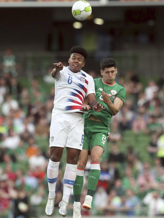 Pemain Amerika Serikat, Weston McKennie (kiri) melakukan duel udara dengan pemain Irlandia, Callum O'Dowda pada laga uji coba di Aviva Stadium, Dublin, (2/6/2018). Irlandia menang 2-1. (Brian Lawless/PA via AP)