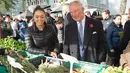 Pangeran Charles berbincang dengan pedagang ketika mengunjungi Swiss Cottage Farmers Market di London utara, Rabu (6/11/2019). Kunjungan Pangeran Charles dan Camila untuk mengucapkan selamat dan memperingati ulang tahun ke-20 pasar tersebut. (Eddie Mulholland / POOL / AFP)