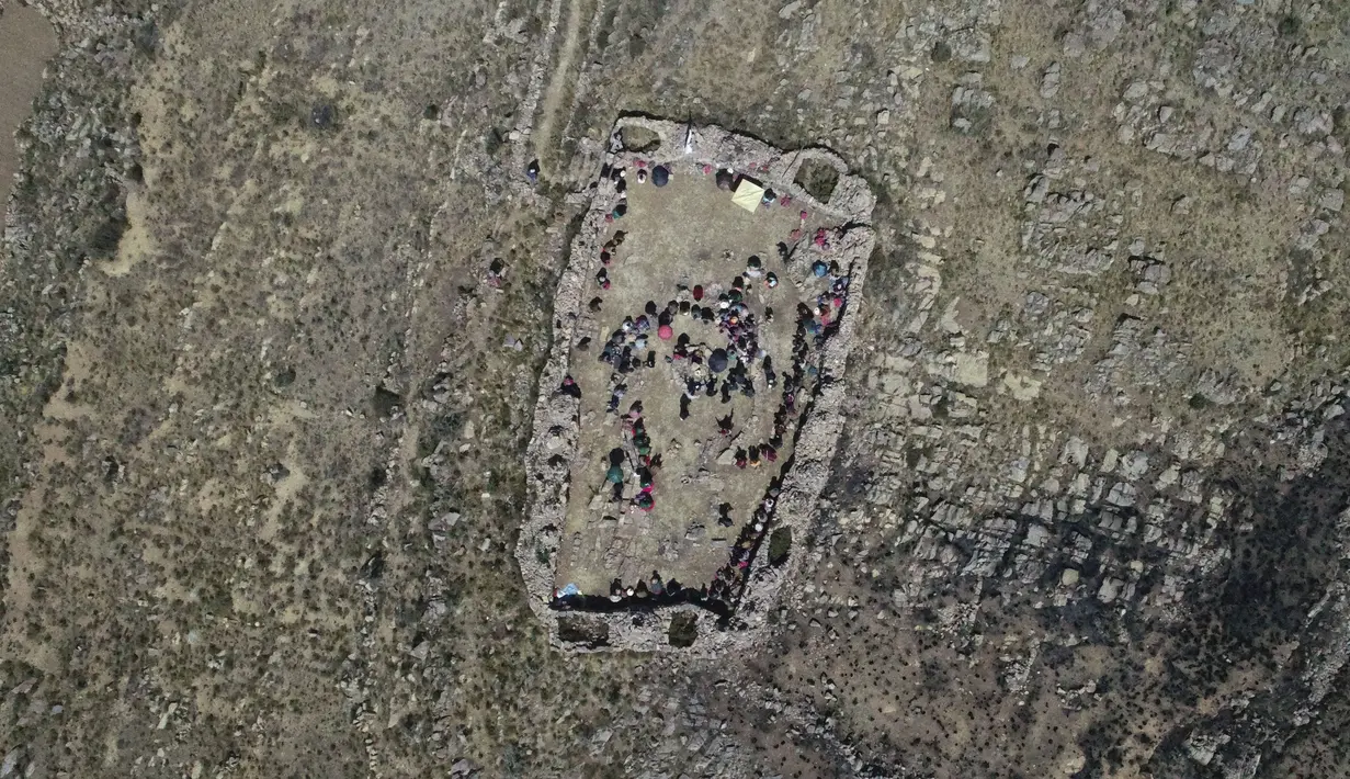Pemandangan dari atas saat suku Aymara berdoa pada hari puasa sebagai ritual meminta hujan di Gunung Suci Inca Pucara, Chiquipata, Bolivia, Rabu (16/11/2022). Penduduk dataran tinggi La Paz mengatakan rendahnya curah hujan yang terjadi sejak September membuat mereka tidak bisa menanam kentang, buncis, dan kacang polong. (AP Photo/Juan Karita)