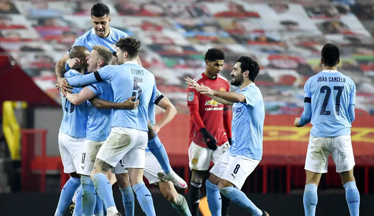 Para pemain Manchester City merayakan gol yang dicetak oleh Fernandinho ke gawang Manchester United pada laga Piala Liga Inggris di Stadion Old Trafford, Rabu (6/1/2021). City menang dengan skor 2-0. (Peter Powell/Pool via AP)