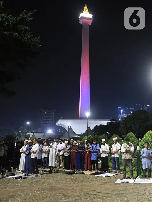 Massa salat bersama saat mengikuti acara Munajat dan Maulid Akbar 2019 #ReuniMujahid212 di kawasan Monas, Jakarta, Senin (2/12/2019). Dalam acara tersebut, massa turut mendoakan agar Imam Besar FPI Rizieq Shihab segera dipulangkan. (Liputan6.com/Herman Zakharia)