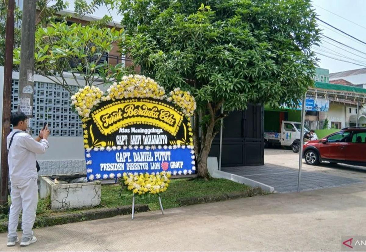 Jurnalis sedang memotret kediaman mendiang capt andy pilot pesawat atr 42-500 jatuh di maros