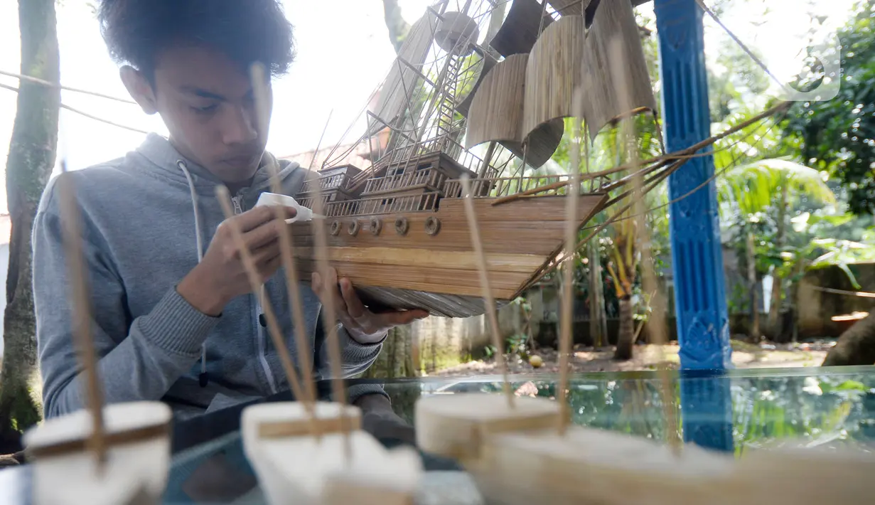 Perajin menyelesaikan pembuatan miniatur kapal pinisi yang terbuat dari limbah bambu di Pondok Benda, Pamulang, Tangerang Selatan, Senin (09/11/2020). Kerajinan berbahan bambu bekas yang dijual dengan harga berkisar Rp.50 ribu hingga Rp.250 ribu tergantung ukurannya. (merdeka.com/Dwi Narwoko)