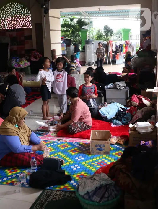 Aktivitas warga saat mengungsi di halaman Masjid Jami Al-Jihad, Perumahan Periuk Damai, Tangerang, Banten, Selasa (23/2/2021). Banjir setinggi 2,5 meter membuat warga harus mengungsi di tempat yang aman. (Liputan6.com/Angga Yuniar)