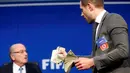 Komedian asal Inggris, Lee Nelson sebelum melemparkan uang kertas ke Presiden FIFA Sepp Blatter saat konferensi pers di markas FIFA di Zurich, Swiss (20/7/2015). Kedatangan Nelson membuat jumpa pers tertunda beberapa saat. (REUTERS/Arnd Wiegmann)