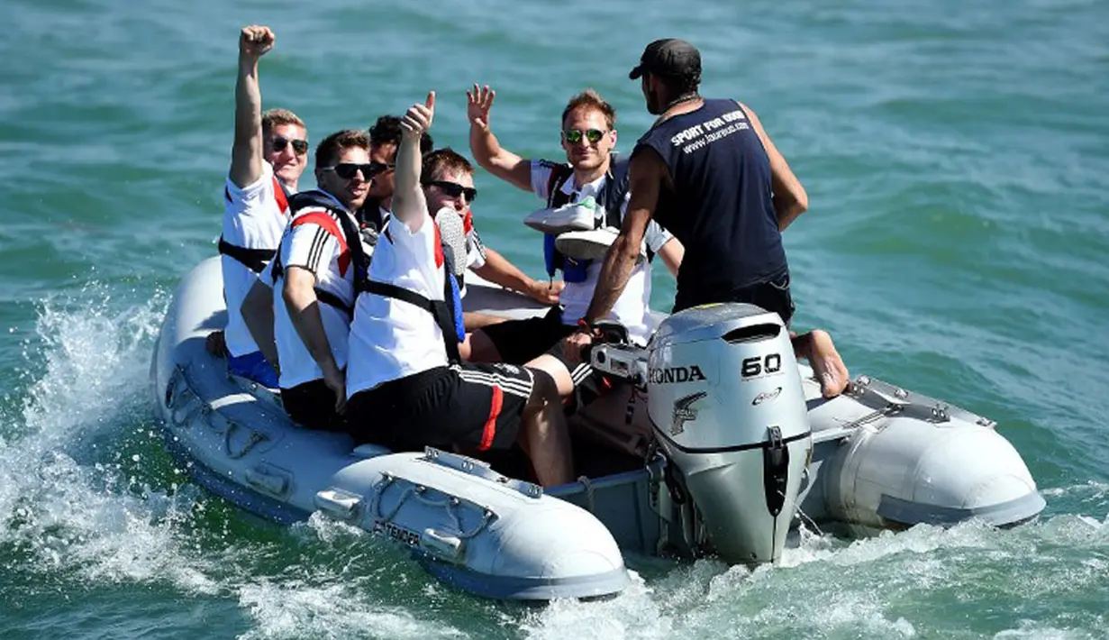 Beberapa punggawa Timnas Jerman terlihat duduk di atas perahu motor menuju kapal di salah satu pantai dekat Santo Andre, Sao Paolo, Brasil, (10/6/2014). (AFP PHOTO/Markus Gilliar)