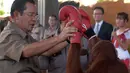 Perdana Menteri Kamboja Hun Sen memegang orangutan setelah pertunjukan kick boxing saat persemian pembukaan Phnom Penh Safari di Kamboja, Sabtu (23/6). (AFP/Tang Chhin Sothy)