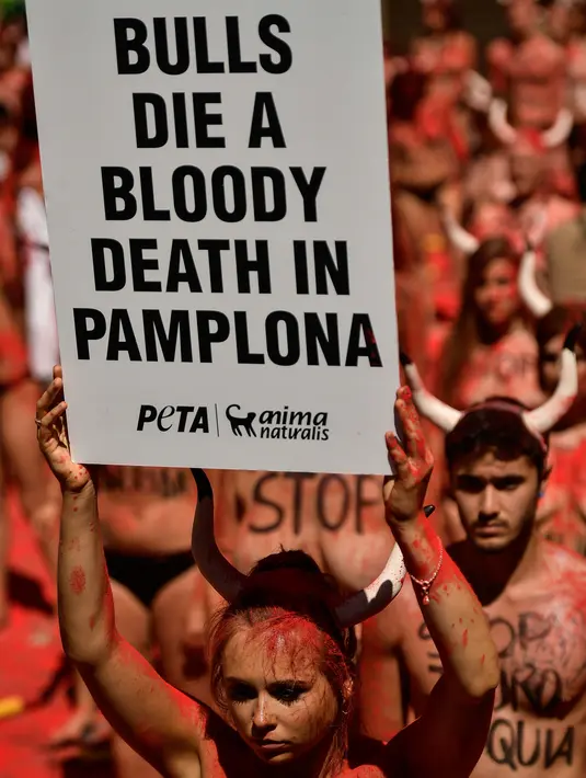 Seorang Aktivis berunjuk rasa memprotes adu banteng dalam Festival San Fermin di depan Balai Kota di Pamplona, Spanyol utara, (5/7). Festival ini melibatkan banyak orang dalam pertunjukan adu banteng, musik dan tarian. (AP Photo/Alvaro Barrientos)