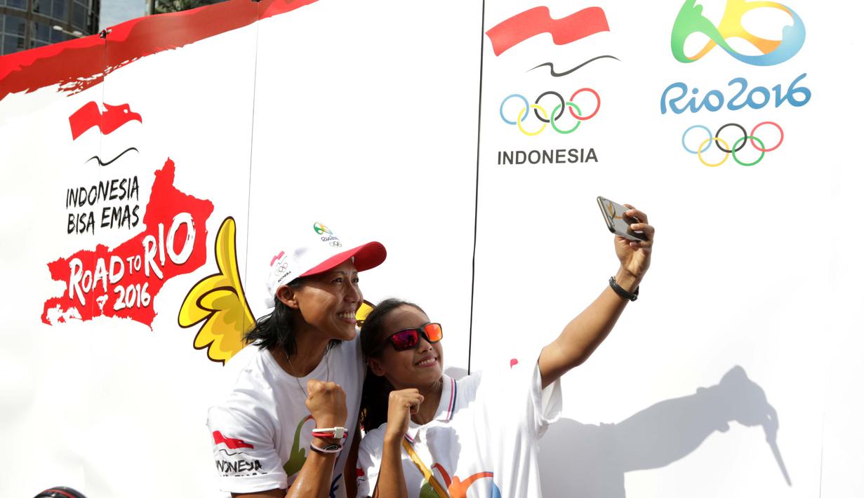 Atlet Indonesia Dedeh Erawati (kiri) dan Triyaningsih berfoto selfie saat kampanye Indonesia Bisa Emas, Road to Rio 2016 di Senayan, Jakarta, Minggu (20/3/2016). (Bola.com/Nicklas Hanoatubun)