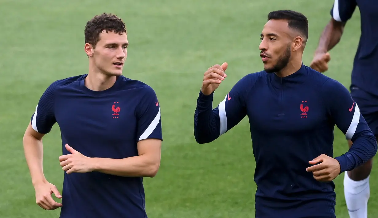Bek timnas Prancis Benjamin Pavard (kiri) berbincang dengan Corentin Tolisso selama sesi latihan MD-1 di Stadion Hidegguti di Budapest, Selasa (22/6/2021). Prancis menghadapi Portugal pada laga Grup F Euro 2020 di Puskas Arena, Rabu (23/6/2021) atau Kamis dini hari WIB. (FRANCK FIFE / AFP)