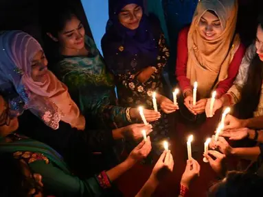 Sejumlah wanita Bangladesh menghadiri nyala lilin untuk memperingati Hari Perempuan Internasional di Dhaka (7/3). Hari Perempuan Internasional secara resmi dijadikan sebagai hari libur nasional di Soviet Rusia pada tahun 1917. (AFP Photo/Munir Uzzaman)