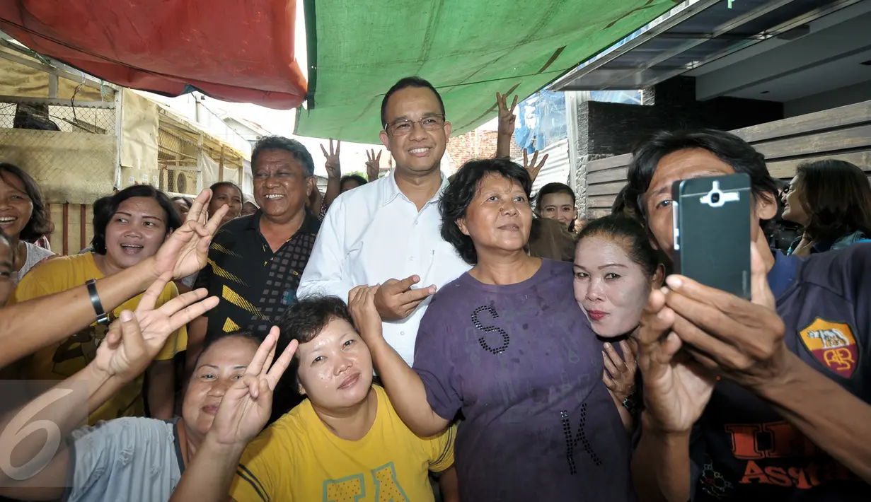 Cagub DKI Jakarta Anies Baswedan berfoto bersama warga yang bermukim di bantaran Kali Krukut, Jakarta Barat, Kamis (3/11). Kepada warga, Anies berjanji memprioritaskan penataan wilayah tanpa melanggar prinsip kemanusiaan. (Liputan6.com/Yoppy Renato)