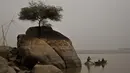 Seorang nelayan duduk di atas batu menangkap ikan di sungai Brahmaputra di desa Kasoshila di Gauhati, India (21/10/2019). Brahmaputra adalah salah satu sungai terbesar di Asia, yang melewati wilayah Tibet China, India, dan Bangladesh sebelum konvergen ke Teluk Benggala. (AP Photo/Anupam Nath)
