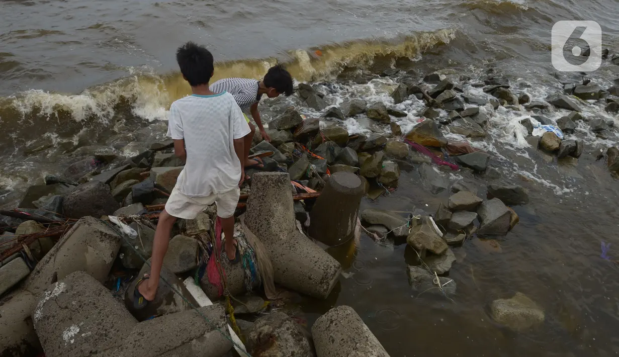Aktivitas warga di pantai Marunda dan kawasan Si Pitung, Jakarta, Kamis (9/12/2021). Di beberapa titik masih tergenang akibat banjir rob (air laut pasang) dan gelombang  pasang air laut merupakan masalah serius yang dihadapi beberapa wilayah pesisir di Indonesia. (merdeka.com/Imam Buhori)